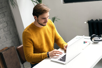 Wall Mural - Portrait of young man sitting at his desk in the office