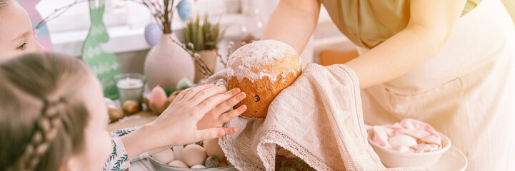 Wall Mural - happy easter holiday time in spring season. family kid girls children sisters and woman holds baked pastry cake or traditional bread in her hands. handmade food. festive home decor. banner. flare