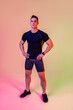 Athletic man with fit muscular body training in studio - Active man doing a workout, colorful lighting and background, concepts about fitness, sport and healthy lifestyle