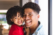 © Wavebreak Media - Portrait of cheerful hispanic father and son with curly black hair at home