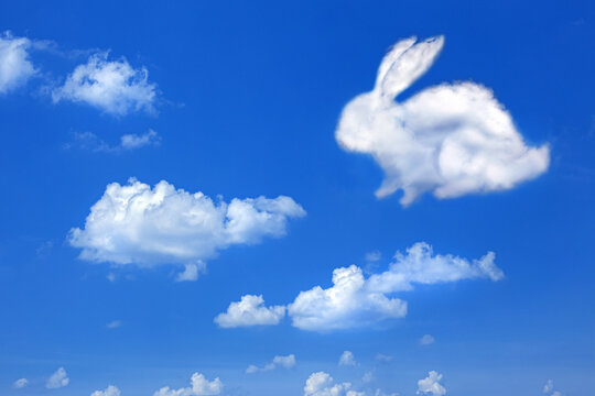 Wall Mural - fluffy cloud Easter bunny on a cloudy sky blue background,