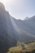 Sunbeams Over A Mountainous Area, A Mountain Cliff With Rocks In The Shade In The Highlands, On A Sunny Summer Morning
