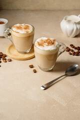 Wall Mural - Two glass cups with coffee drink, latte with milk foam and cinnamon, copy space