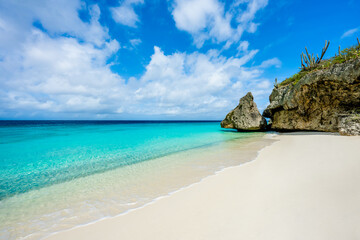 White sand beach with Large rock in background