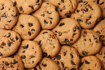 Delicious chocolate chip cookies as background, top view