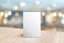 Mock Up Label The Blank Menu Frame In Bar Restaurant. Stand For Booklet With White Sheet Paper Acrylic Tent Card On Table Wiht Blurred Background Can Inserting The Text Or Picture