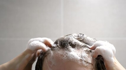 Wall Mural - A girl washes her hair with shampoo on gray background, front view