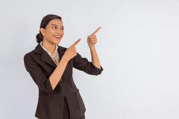 asian woman in formal outfit looking up and pointing with her finger on isolated background