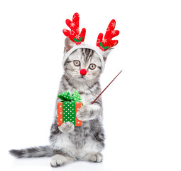 Poster - Funny kitten dressed like santa claus reindeer Rudolf holds gift box and points away on empty space. isolated on white background