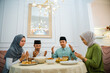© Odua Images - The muslim family prayed together before eating dinner at home