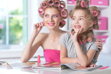 Sticker - Mom and daughter with hair curlers reading magazine