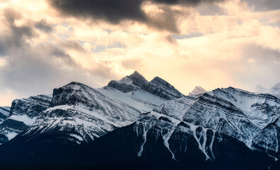 Wall Mural - Snowy summit rocky mountains with sunlight shining in wilderness at national park