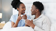 © Nina/peopleimages.com - Bed, coffee cup and married people drink together while they relax in their home bedroom. Marriage, happiness and cheerful black couple bond with friendly talk or silly joke in the morning.