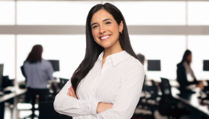 Portrait of a brunette business student in a modern technology office space, standing with arms folded, teamwork and team success concept, wide banner