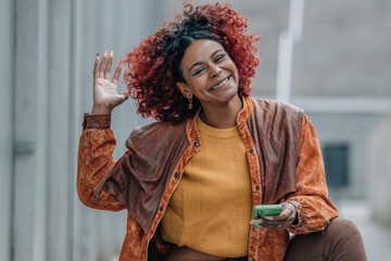 Wall Mural - smiling girl on the street with mobile phone and afro hair