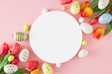 Wall Mural - Easter decorations concept. Top view photo of white circle red tulips flowers colorful eggs on isolated pastel pink background with blank space. Easter card idea