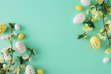 Wall Mural - Easter decor concept. Top view photo of white yellow easter eggs cherry blossom branches on turquoise background with copy space in the middle
