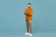 © Home-stock - Full length portrait of young man in casual posing with folded arms smiling at camera on blue background