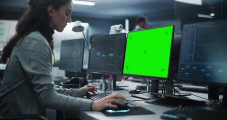 Fototapete - Female Software Developer Working on a Desktop Computer with Green Screen Mock Up Display. Specialist Typing on Keyboard, Coding and Implementing a New Technical Feature, Working in an Agency