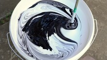 Top View Of Mixing White And Black Paint Using Electric Mixer. Close Up
