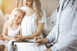 © rogerphoto - Doctor and patient. Pediatrician using clipboard while examining little girl with her mother at home. Happy cute caucasian child at medical exam. Medicine concept.