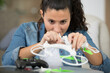 © auremar - young smiling woman assembling drone propeller at home