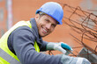 © auremar - worker fixing steel rebar at building site