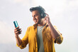© paltu - happy young man enjoying music with headphone and mobile phone