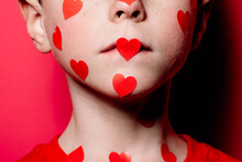 Anonymous Cute Boy In Red Casual Shirt With Red Love Sticker On Face While Posing For Photograph