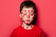 Cute Boy In Red Casual Shirt With Red Love Sticker On Face While Posing For Photograph