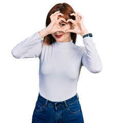 Sticker - Redhead young woman wearing casual turtleneck sweater doing heart shape with hand and fingers smiling looking through sign