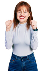 Poster - Redhead young woman wearing casual turtleneck sweater excited for success with arms raised and eyes closed celebrating victory smiling. winner concept.