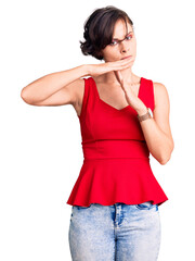 Poster - Beautiful young woman with short hair wearing casual style with sleeveless shirt doing time out gesture with hands, frustrated and serious face