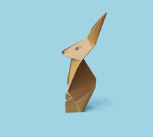 Close Up Brown Origami  Paper Bunny Isolated On A Blue Background With Space For Text. Easter Handmade