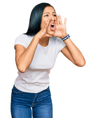 Poster - Beautiful hispanic woman wearing casual white tshirt shouting angry out loud with hands over mouth