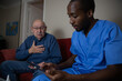 © Media Lens King - An elderly patient touches his chest in pain during a home doctor visit