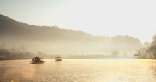 Traditional Chinese Style Boat On River Lake With Fog Misty In The Morning Sunlight Sunrise Against Village Mountain Hill On Background At Ban Rak Thai Village, Mae Hong Son, Northern Thailand