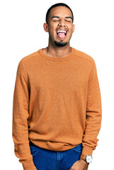 Wall Mural - Young african american man wearing casual clothes sticking tongue out happy with funny expression. emotion concept.