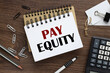 © Svetlana - pay equity. two notepads and a calculator. text on white paper