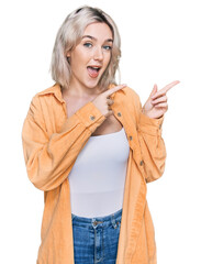 Sticker - Young blonde girl wearing casual clothes smiling and looking at the camera pointing with two hands and fingers to the side.