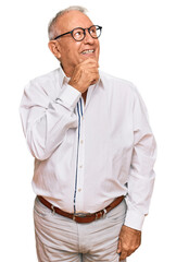 Wall Mural - Senior caucasian man wearing business shirt and glasses with hand on chin thinking about question, pensive expression. smiling with thoughtful face. doubt concept.