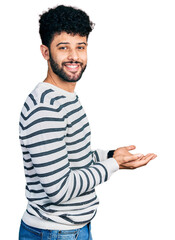 Sticker - Young arab man with beard wearing casual striped sweater pointing aside with hands open palms showing copy space, presenting advertisement smiling excited happy