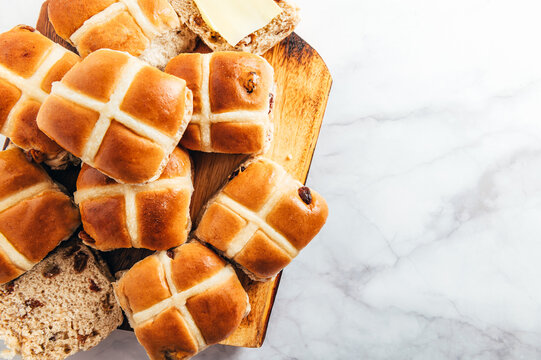 easter breakfast with hot cross buns, served on wooden chopping board. top view