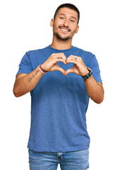 Poster - Handsome man with tattoos wearing casual clothes smiling in love doing heart symbol shape with hands. romantic concept.