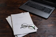 Glasses on a notebook. Financial journal, glasses and a computer.