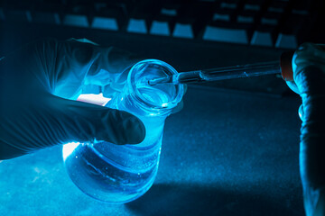 Blue science experiment glass tube,Researchers with chemistry test tubes in a liquid glass lab for analytical, medical, pharmaceutical and scientific research concepts