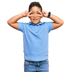 Sticker - Little boy hispanic kid wearing casual clothes doing peace symbol with fingers over face, smiling cheerful showing victory