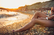© _KUBE_ - women's legs near the sea water at sunset