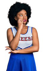 Canvas Print - Young african american woman wearing cheerleader uniform looking stressed and nervous with hands on mouth biting nails. anxiety problem.