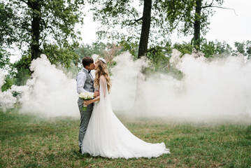 Wall Mural - Romantic wedding moment, couple of newlyweds kissing in nature in the park. Wedding ceremony.